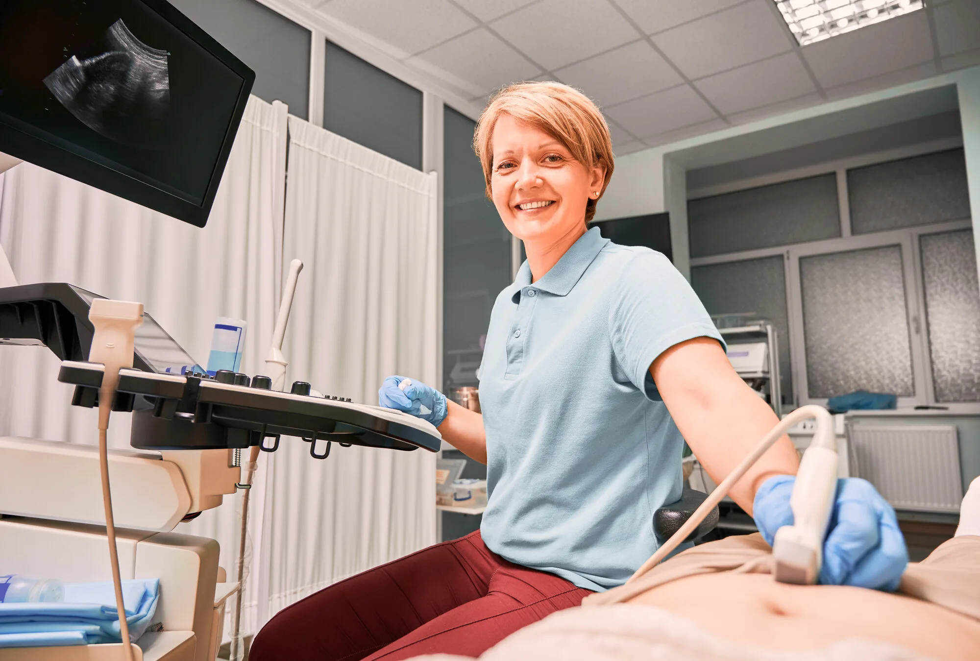 Sonographer performing ultrasound examination in a clinical setting